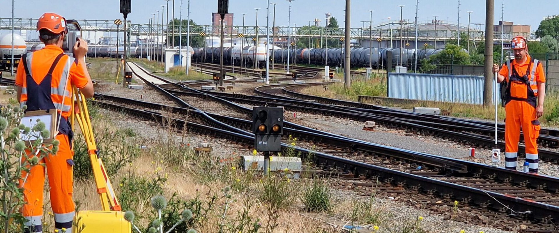 Zwei Vermessungstechniker messen/ stecken an der Gleise was ein/ab